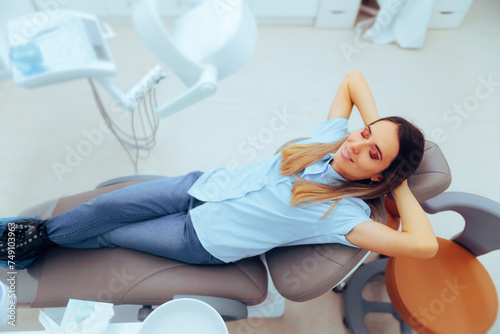 Happy Patient Sitting Comfortable in a Dental Office. Carefree relaxed woman sitting in a dentist cabinet with no fear 