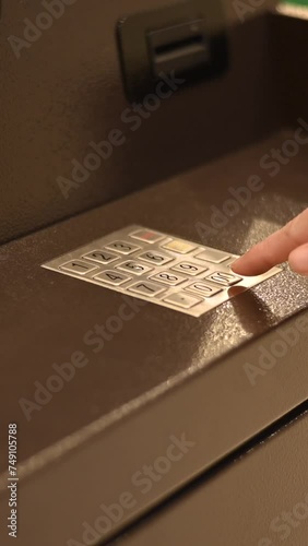 Faceless woman dialing bank card pin at ATM. Vertical video.  photo