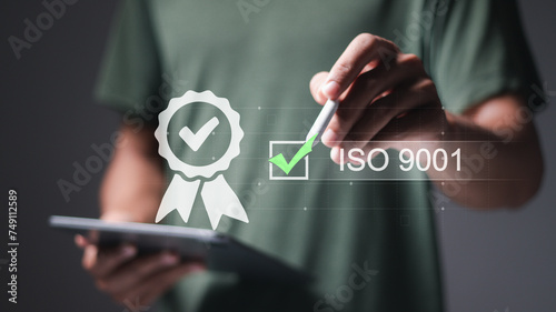 QMS, ISO 9001 Quality Management System concept. Certified and quality management of organizations. Person using tablet with correct checklist for ISO 9001 on virtual screen.