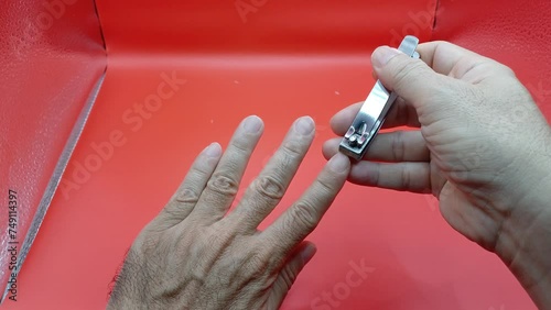 Close-up of man's hand holding clipper and cutting his nails. photo