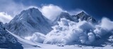 A grand mountain range covered in a thick layer of snow, with clouds hugging the peaks, creating a breathtaking view. The landscape is transformed into a winter wonderland, with the snow and clouds