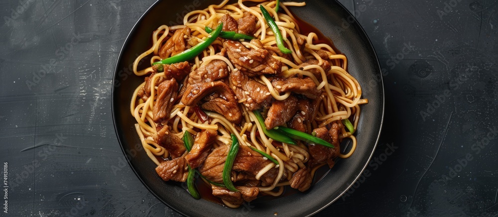 A dish featuring stir-fried shredded pork and green peppers served on a bed of loose noodles. The noodles are topped with a generous portion of tender meat and colorful vegetables, creating a savory
