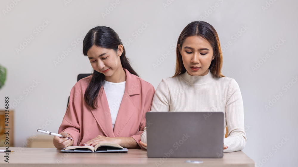 Two young asian happy business women working together for analyze planning and financial statistics and investment market in home office space Two young asian happy business women working together for analyze planning and financial statistics and investment market in home office space