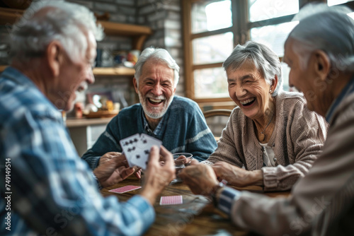 Group of happy senior people laughing while playing cards together at home photo