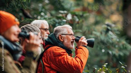 A group of senior citizens (60s+) birdwatching in a forest
