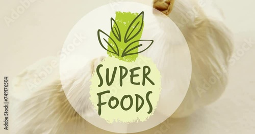 Animation of super foods text over garlic on white background photo