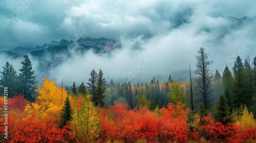 Clouds over colorful autumn trees with majestic mountains in the Background