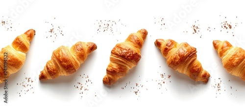 A group of freshly baked croissants arranged neatly on a white surface, creating a visually appealing French breakfast concept. The golden-brown pastries are a delicious and flaky treat that promote