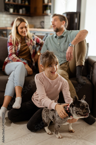 Family bonding time with playful french bulldog pup in cozy living room
