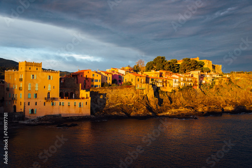 Village de Collioure. Lever de soleil sur le village de Collioure. Lumière dorée, heure des peintres sur un village méditerranéen. Village côtier. Littoral de la mer méditerranée. Ciel orageux. photo