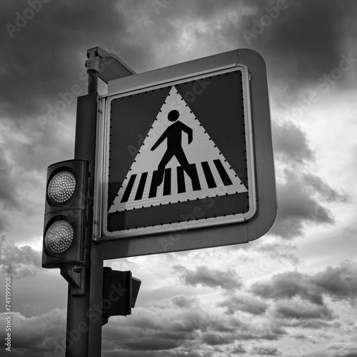 Black and White Crosswalk Road Sign with Dark Clouds in the Background