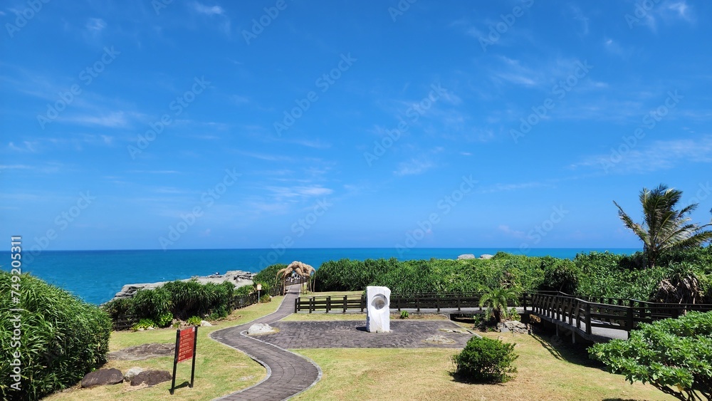 Fototapeta premium Coastal Serenity: Seaside Bliss with Beachside Rocks and Charming Homes in Nature's Embrace
