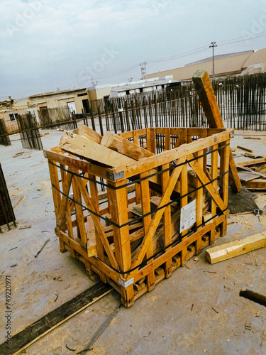 A wooden crate is sitting on the ground. The crate is full of wood and has a label on it