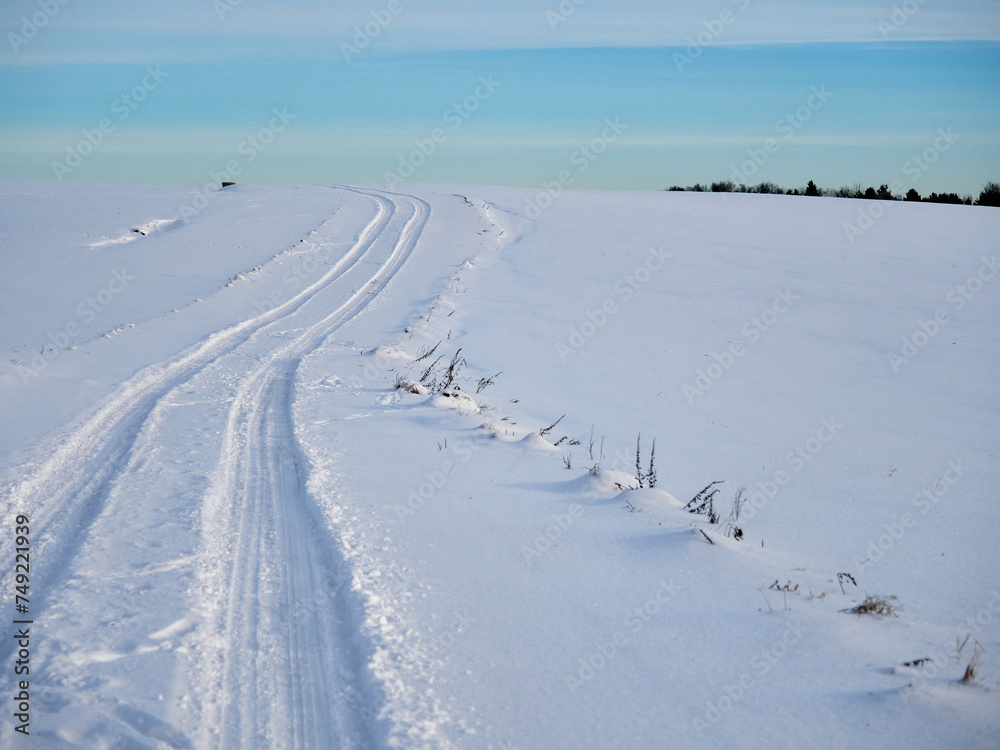 Winter evening landscape. Winter field and road in the snow. Snow and sky