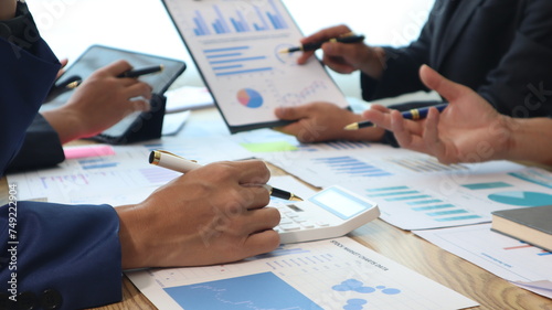 Close up of hands of business people working together in a conference room, brainstorming, discussing and analyzing and planning business strategies.