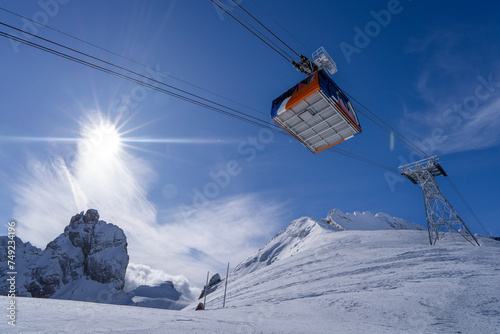 Sun-Kissed Peaks and Vibrant Cable Car in the Italian Alps