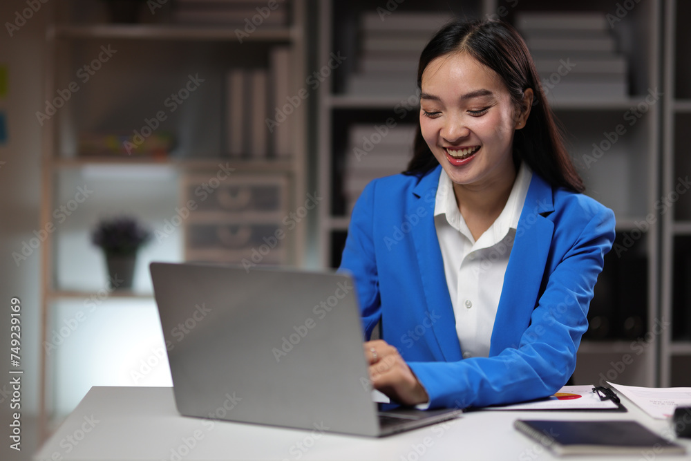 Attractive Asian businesswoman working overtime with documents on desk in office. Attractive Asian businesswoman working overtime with documents on desk in office.