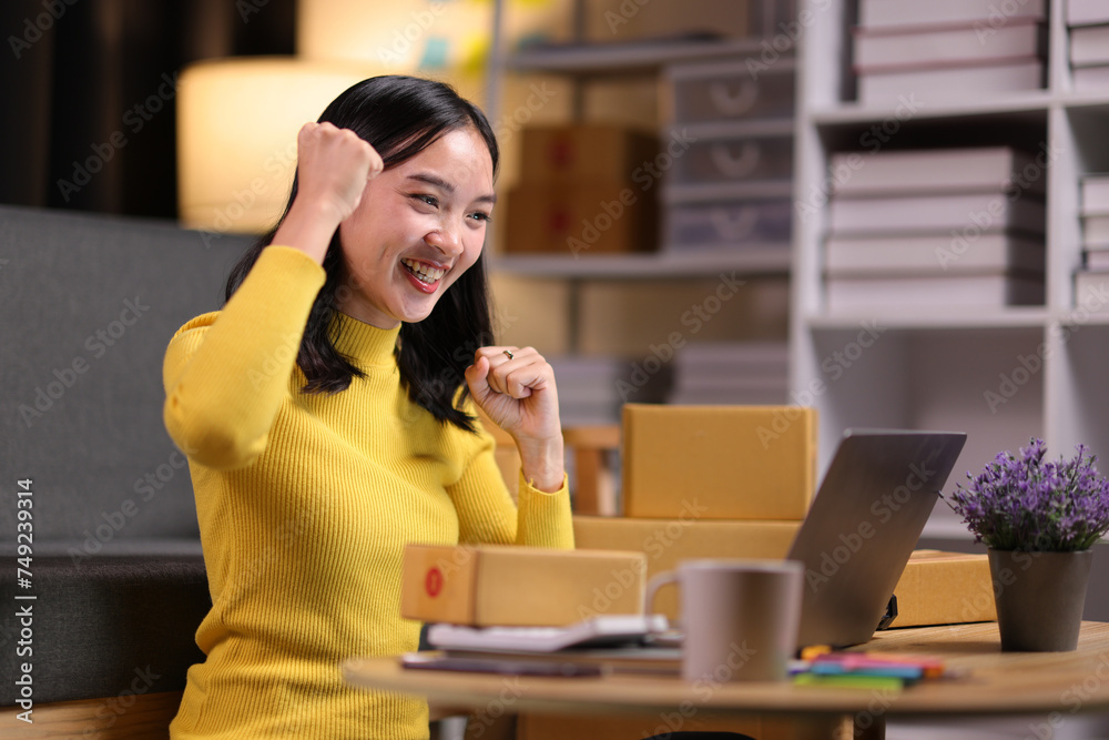 A young Asian woman started an online sales business as a part-time job, She is working with shipping boxes to prepare for home delivery of an internet order. A young Asian woman started an online sales business as a part-time job, She is working with shipping boxes to prepare for home delivery of an internet order.