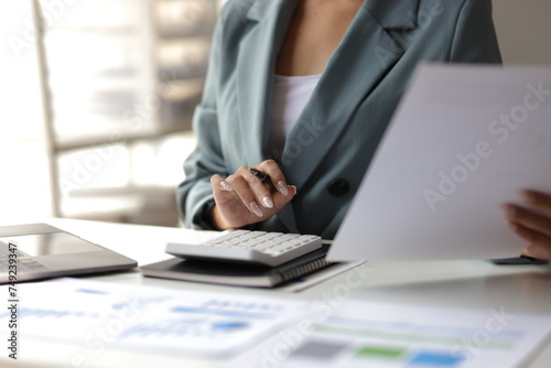 Businesswoman working with documents is analyzing financial data statistically, calculating income and expenses, managing budgets and planning finances. photo