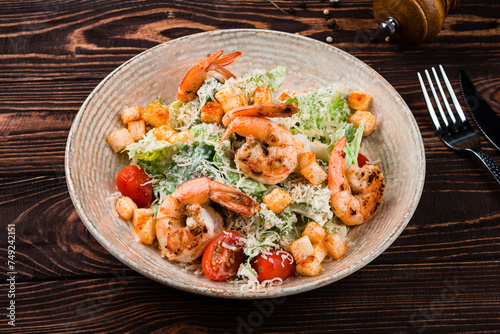 Caesar salad with shrimps, parmesan cheese, lettuce, cherry tomatoes and croutons.