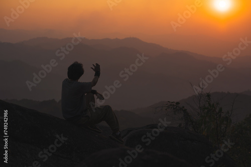 landscape and travel concept with solo freelancer man relax at top of mountain and sunset with layer of mountain