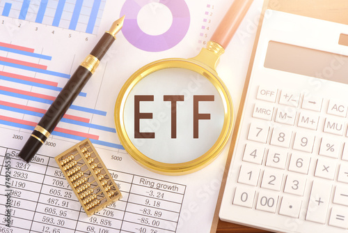 The magnifying glass on the chart is printed with the letter ETF