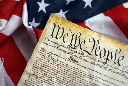 Preamble to the Constitution of the United States and American Flag. Old yellow paper with We The People text photo