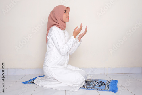 Moslem Asian woman looking up when praying photo