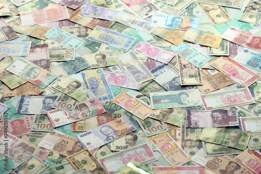 Many banknotes of different currency. Background of big amount of random money bills close up