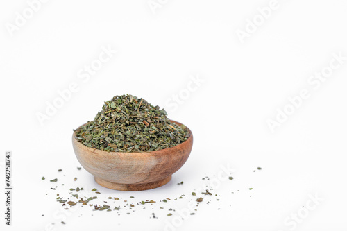 Suszone zgniecione zielone zioła w miseczce, aromatyczne oregano  izolowane na białym tle