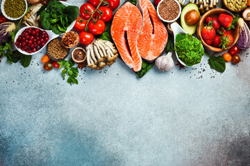 Top view. Healthy food selection on gray background. Detox and clean diet concept. Foods high in vitamins, minerals and antioxidants. Anti-aging foods.
