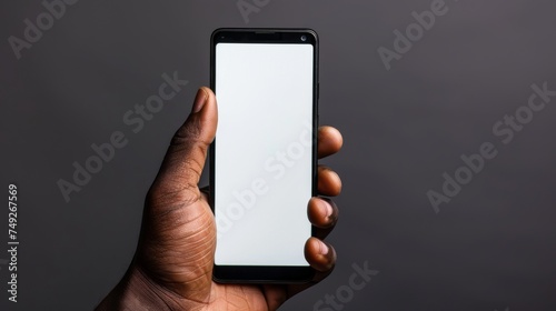 hand is holding a smartphone with a blank white screen, ready to display any content or application