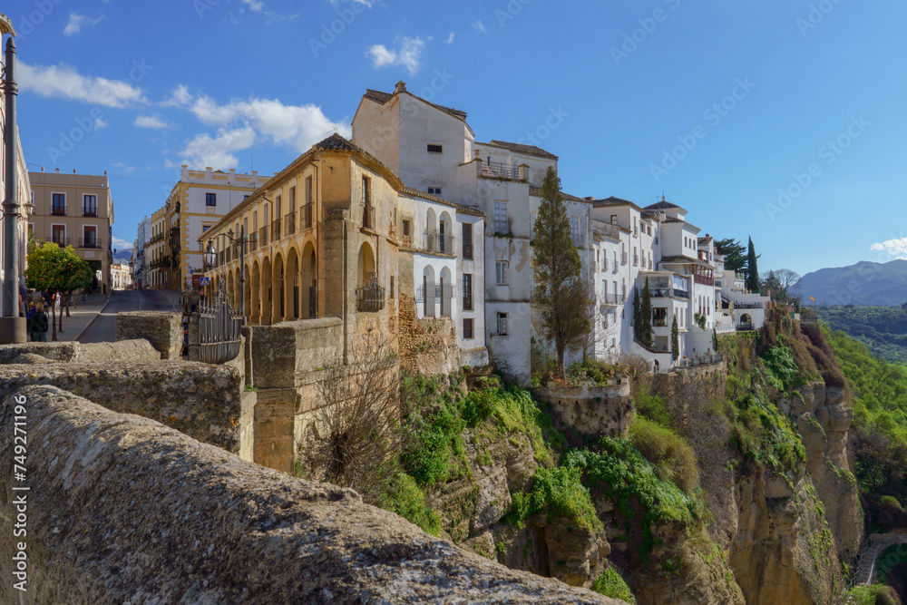 view of the buildings of the city of ronda,malaga,spain at the edge of the cliff with a blue sky with clouds
