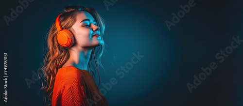 Teen girl wearing headphones, listening music. Dark neon background.