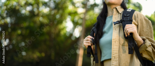 Cropped shot female tourist with backpack hiking at springtime. Travel and active life concept