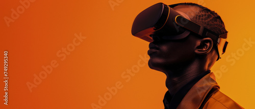 A man deeply focused while using a virtual reality headset, contrasted with an orange background highlighting a modern and immersive experience