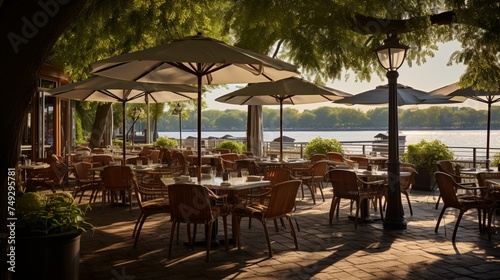 A riverside restaurant patio with tables set under shady umbrellas