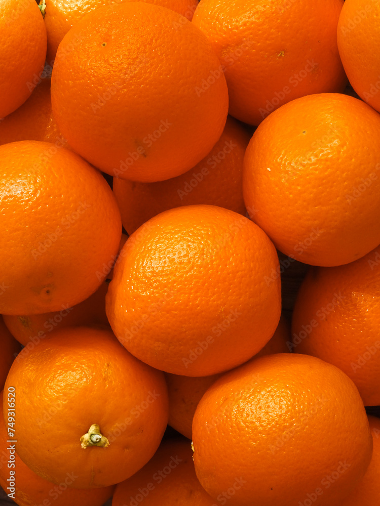 Pile of organic oranges in the market. Fruit orange background. Vertical Pile of organic oranges in the market. Fruit orange background. Vertical