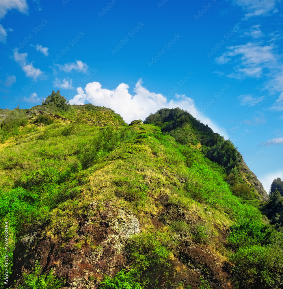 Mountain, green and natural landscape with blue sky, summer and calm clouds on peak at travel location. Nature, cliff and sustainable environment with earth, forest and tropical holiday destination