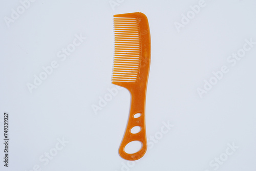 a brown plastic comb with a hollow handle on a white background    
