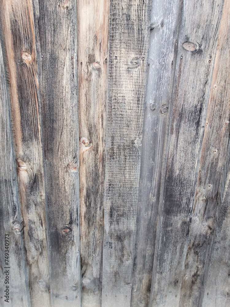 background of old wooden fence panels, faded from the sun and darkened from excess moisture
