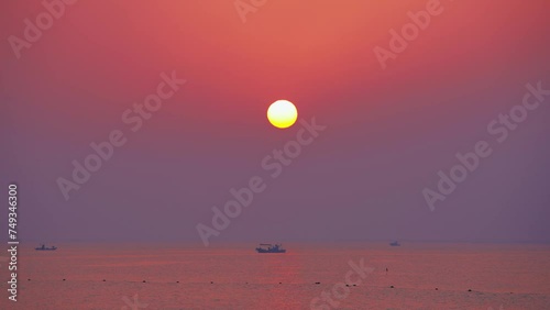 the sunrise of the sea on which a ship is floating