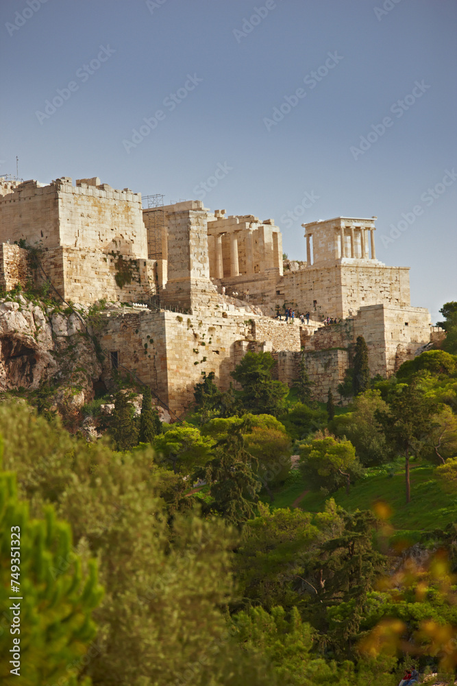Architecture, artistic building and history of parthenon in Athens Acropolis with trees, nature and grass in Greece. Traditional temple, design and walls in landscape blue sky, rocks and marble