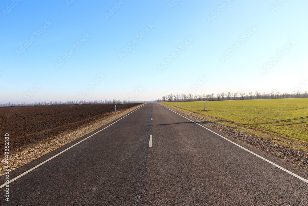 Asphalt road near agricultural fields and blue sky on a backround Asphalt road near agricultural fields and blue sky on a backround