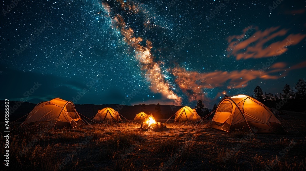 Camping under the Stars: A cozy campsite under a starry night sky, with a crackling campfire and silhouetted tents, conveying the joy of outdoor camping - obrazy, fototapety, plakaty 