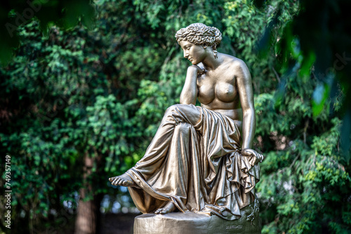 Historical cast iron Statue of half naked Woman called "Dreaming" surrounded by trees