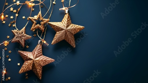 Golden garland in the shape of stars on a dark blue background with empty copyspace for text for Christmas, New Year