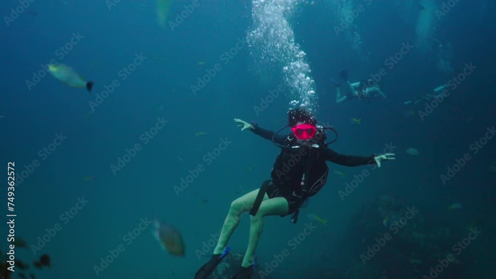 A diver swimming among fish and corals A diver swimming among fish and corals