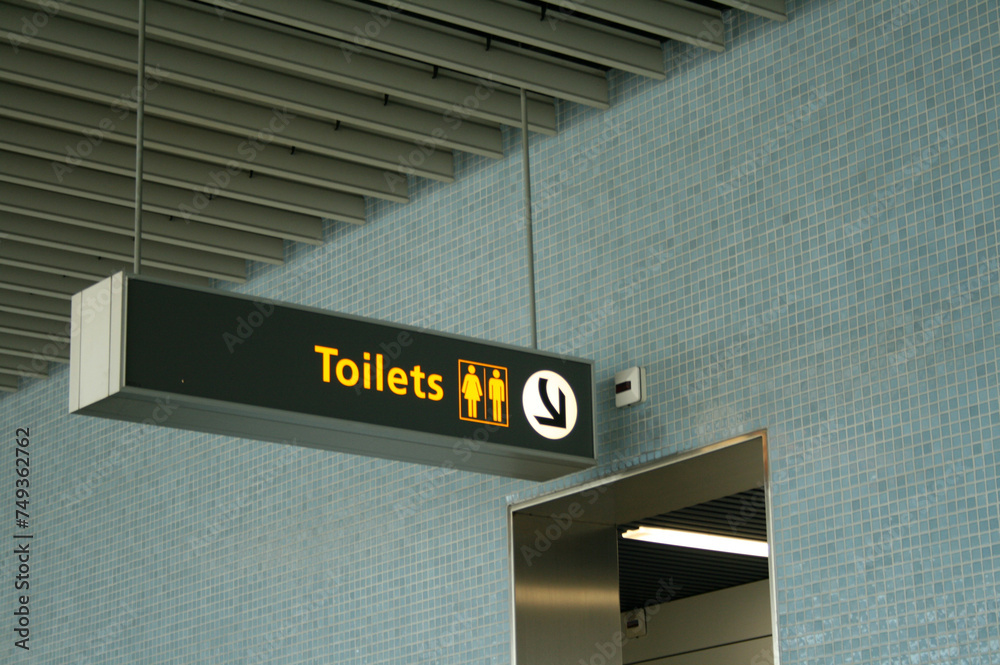 Airport Toilet Sign. This photo was taken on August 25, 2008 in Amsterdam, the Netherlands. The light blue tiles on the walls and the signage for the restrooms are modern. Airport Toilet Sign. This photo was taken on August 25, 2008 in Amsterdam, the Netherlands. The light blue tiles on the walls and the signage for the restrooms are modern.