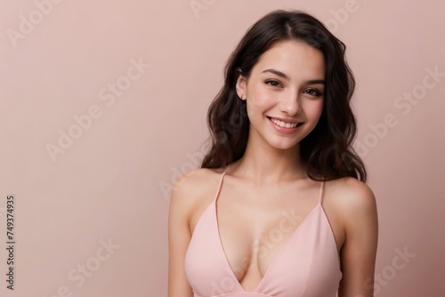 Gorgeous young woman with wavy hair on a pastel pink background.